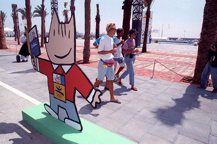 Uns esportistes passejant per la Vila Olímpica amb el Cobi, la mascota dels jocs, durant el juliol del 1992. 