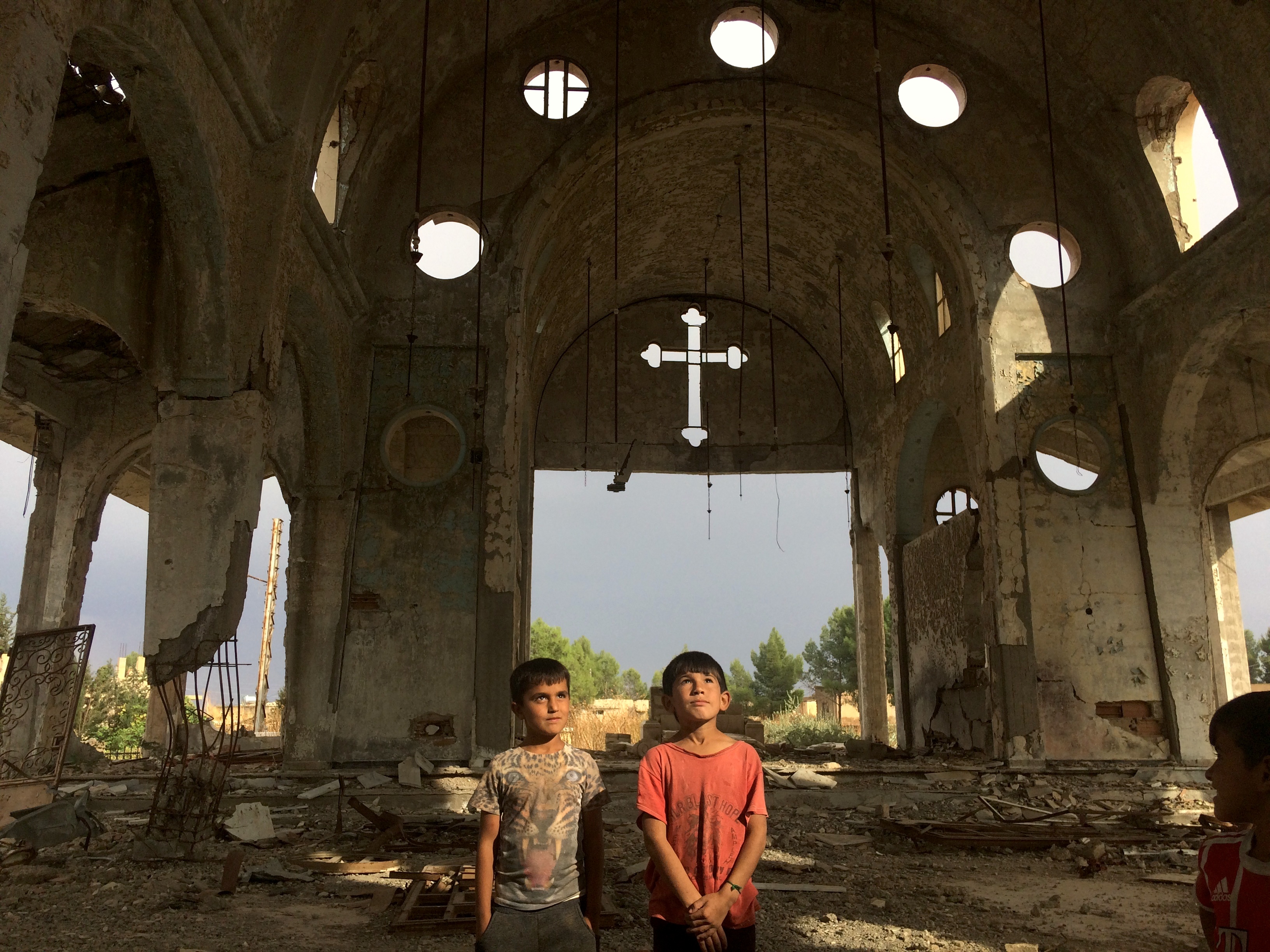 Un grup de nens de Serekaniye, desplaçats per l'ofensiva turca, entre les runes de l'església de Tel Nasri. 