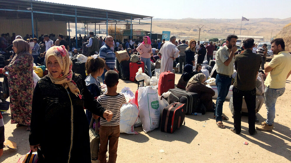 Cientos de kurdos con maletas y bolsas en el control fronterizo entre el Kurdistán sirio y el iraquí.