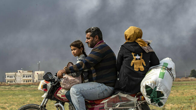 Una pareja con su hija y algunas pertenencias huyendo de su pueblo cerca de Serekaniye para refugiarse de la ofensiva turca en Tel Amer.