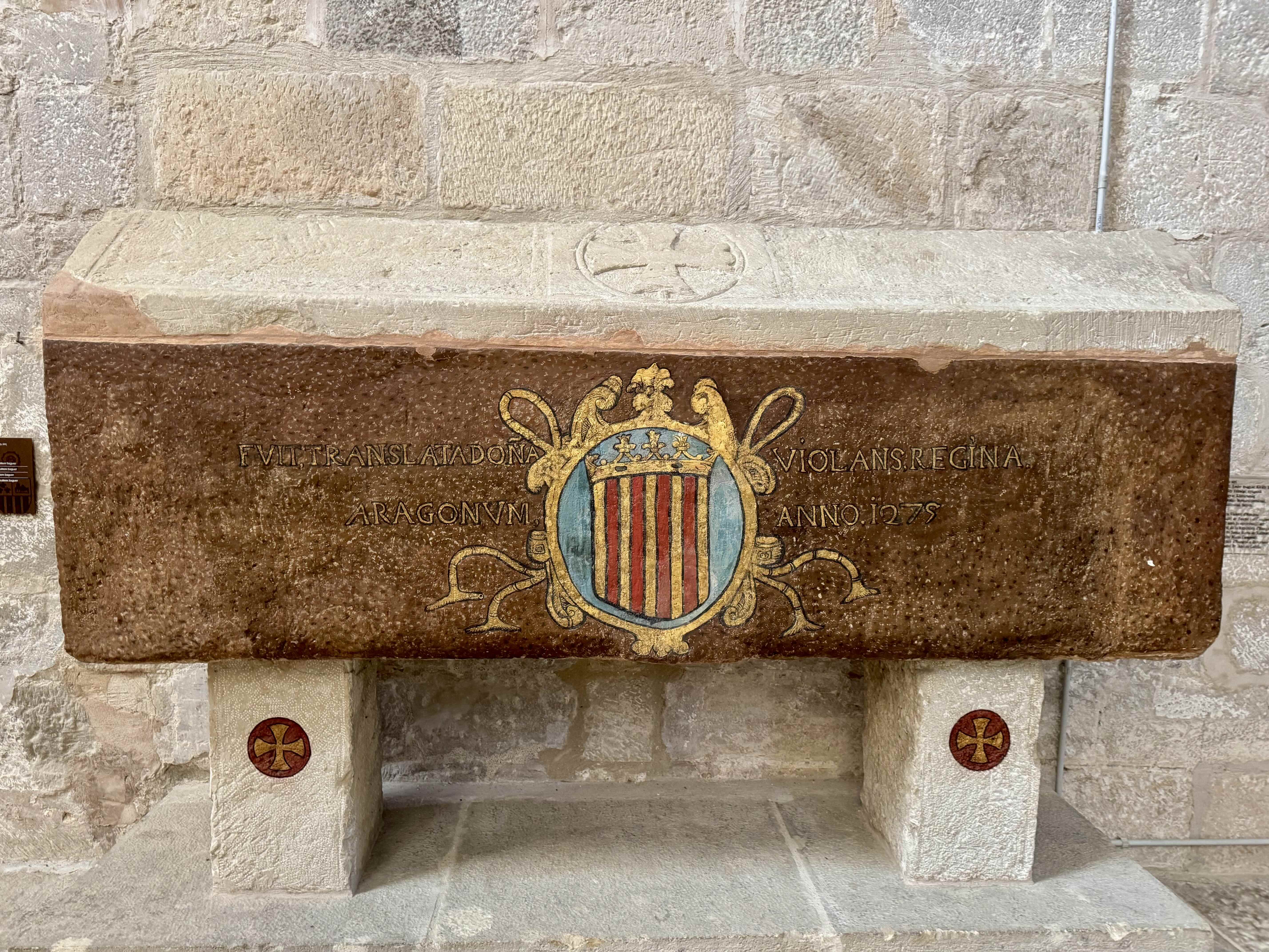 El sepulcre de la reina Violant d'Hongria. Alçat sobre dos pilastres, la caixa és de pedra vermellosa i la coberta de pedra blanca a dos vessants. / A.F.